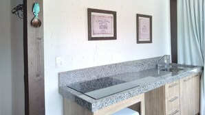 Une cuisine dotée de plans de travail en granit, de meubles en bois et de deux certificats encadrés accrochés au mur.
