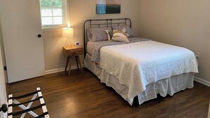 A bedroom with a bed, a nightstand with a lamp, a ceiling fan, and a window with blinds. - Convenient 3 Bedroom / 2 Bath house (Gainesville)