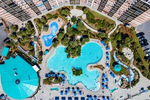 An aerial view of a resort with multiple swimming pools, landscaped areas, and a large central pool. - Edgewater Tower 2 Unit 505 (Panama City Beach)
