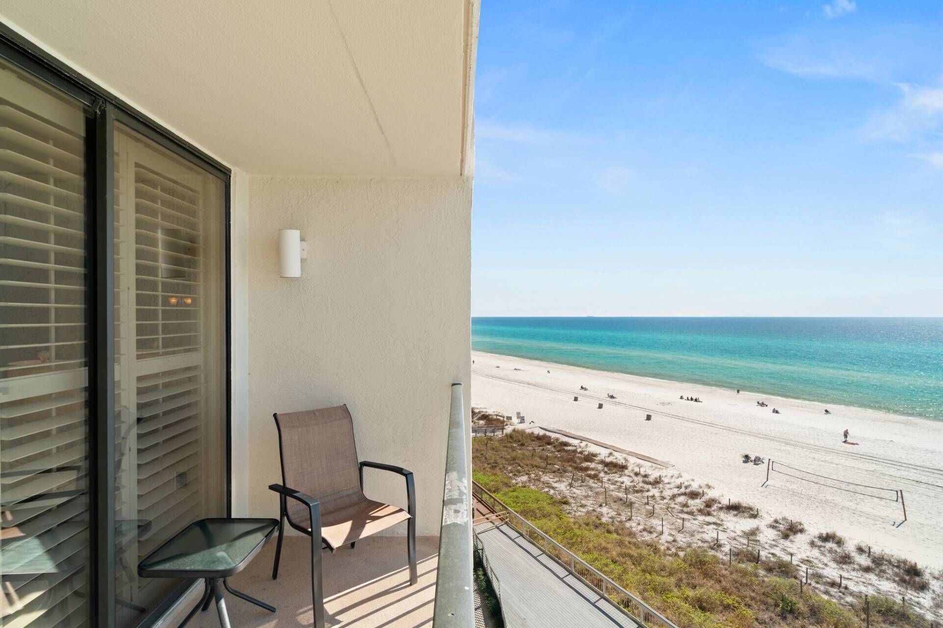 A balcony with a view of a beach and ocean.