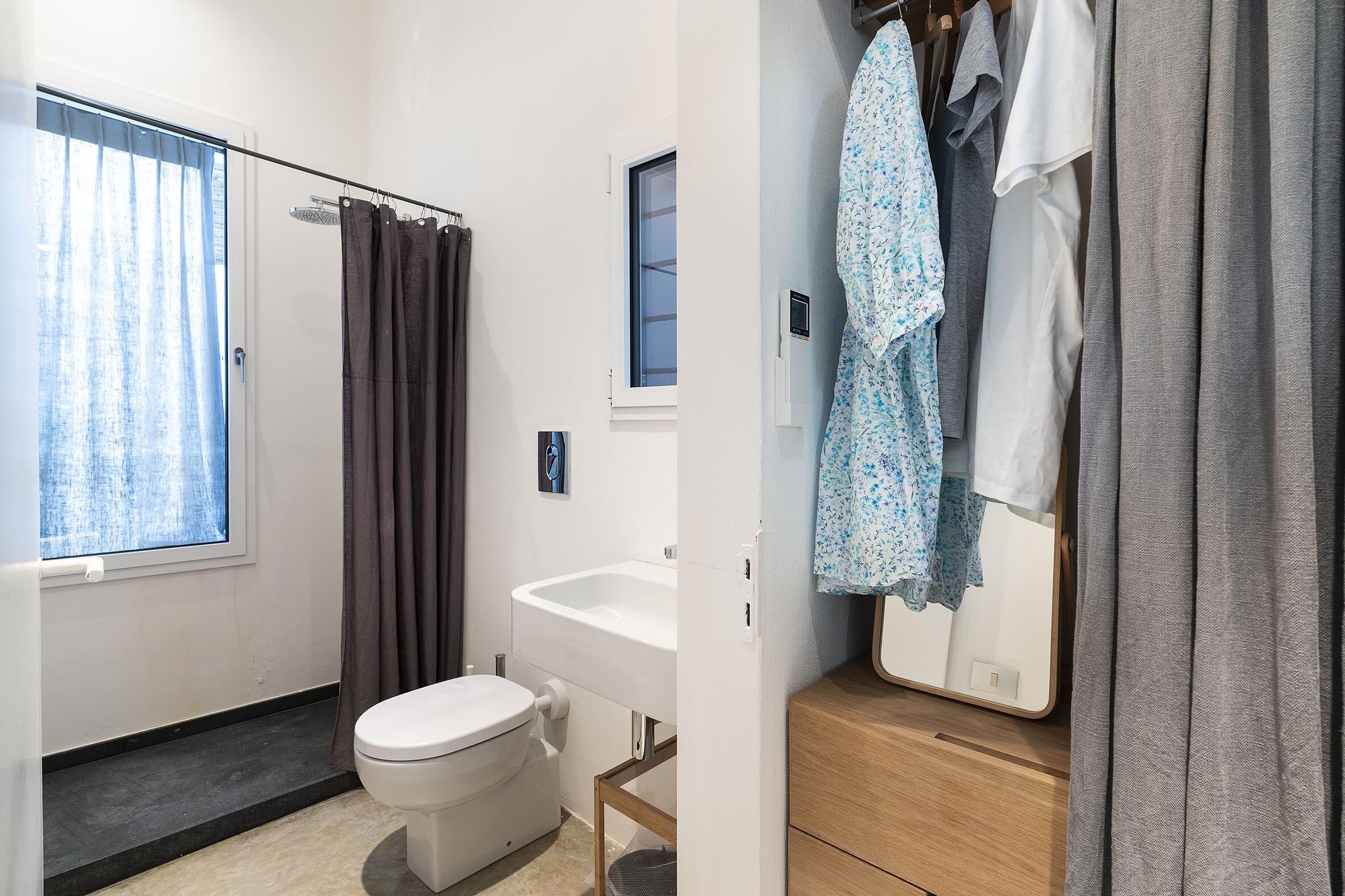 Ein modernes Badezimmer mit Toilette, Waschbecken und Duschbereich.