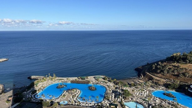 Ein Resort mit mehreren Swimmingpools, einem Strand und Blick auf den Ozean.