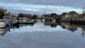 A calm water body with boats docked, surrounded by residential buildings. - Sleeping on the water (Zwartsluis)