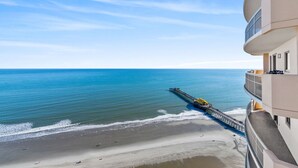 A beachfront hotel with a pier extending into the ocean, offering ocean views. - $150 activities - E-gift card when you book - Stunning Oceanfront Retreat in Gated Community | M2303 (Myrtle Beach)