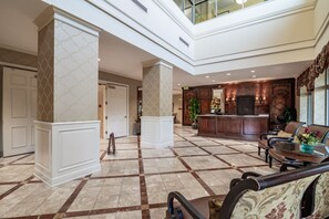 A spacious lobby with a high ceiling, a reception desk, seating area, and a check-in counter. - $150 activities - E-gift card when you book - Stunning Oceanfront Retreat in Gated Community | M2303 (Myrtle Beach)
