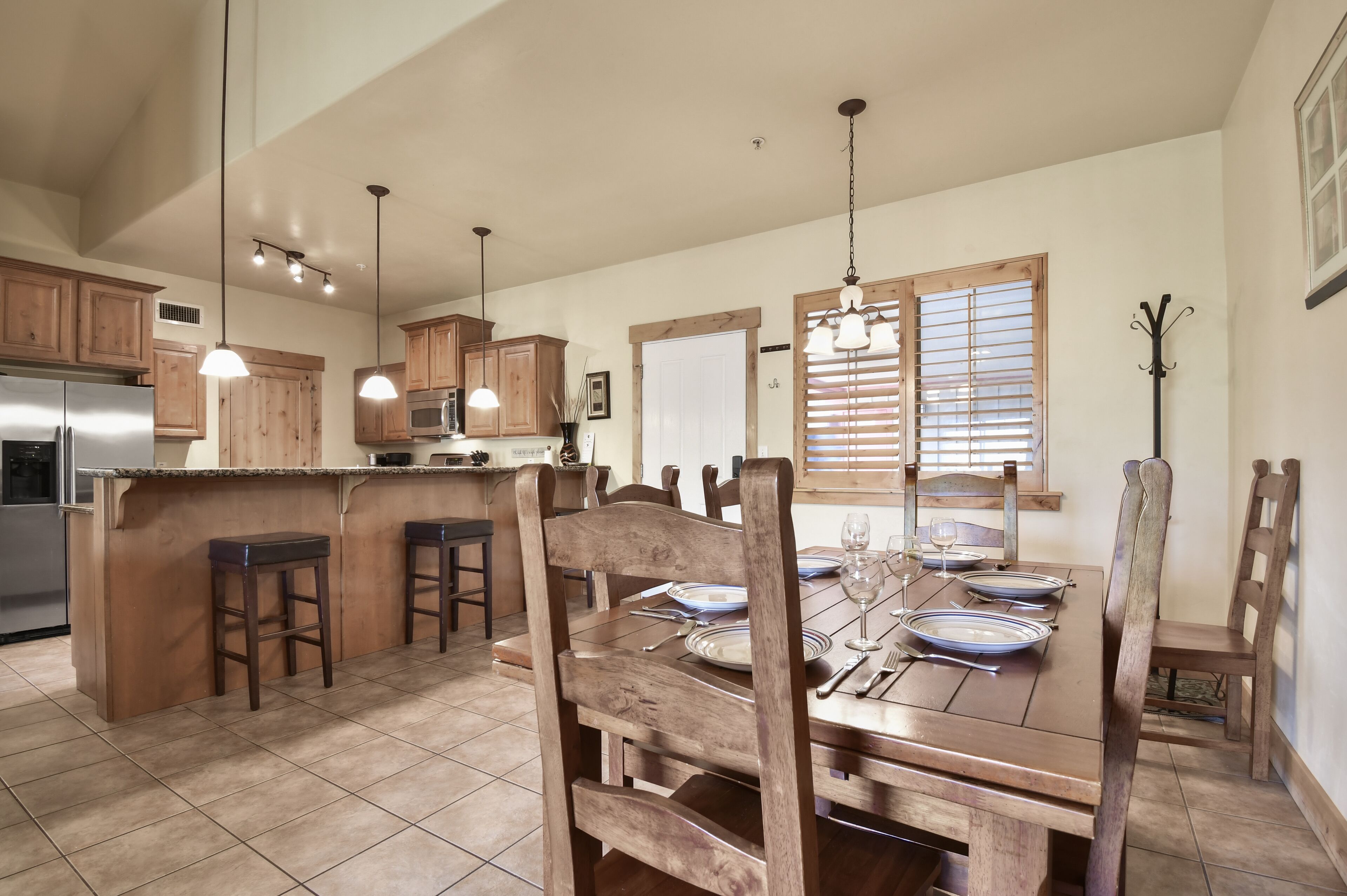 Gather around the rustic wooden dining table that comfortably seats 6, located just off the kitchen for convenient meals together.