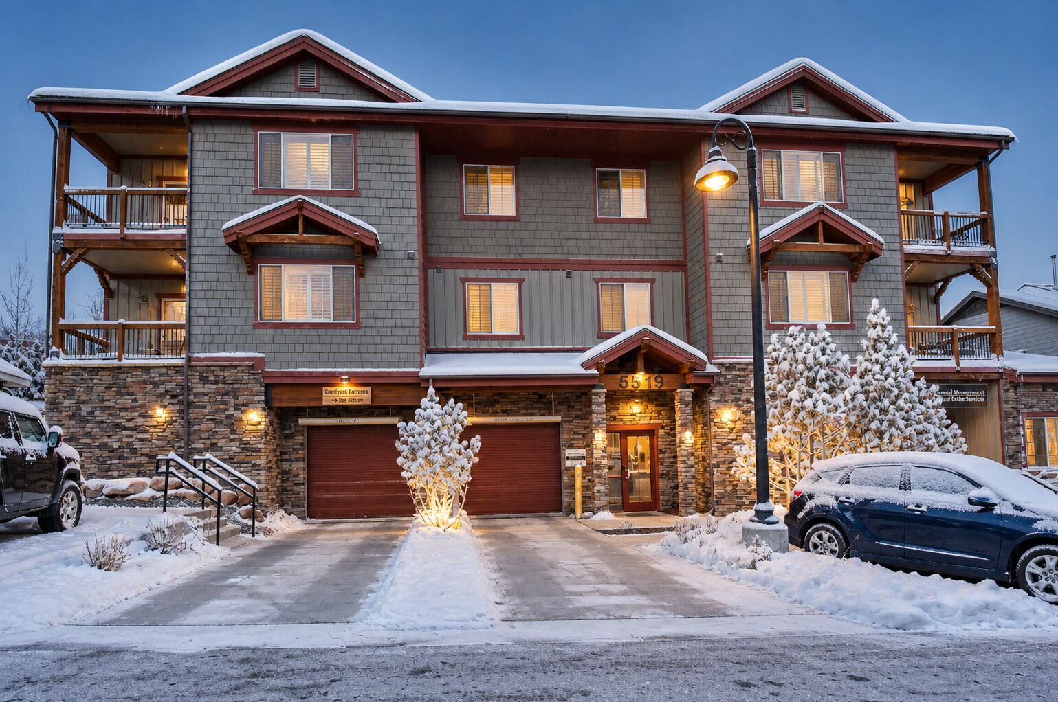 A multi-story building with a stone facade, multiple balconies, and a garage entrance.