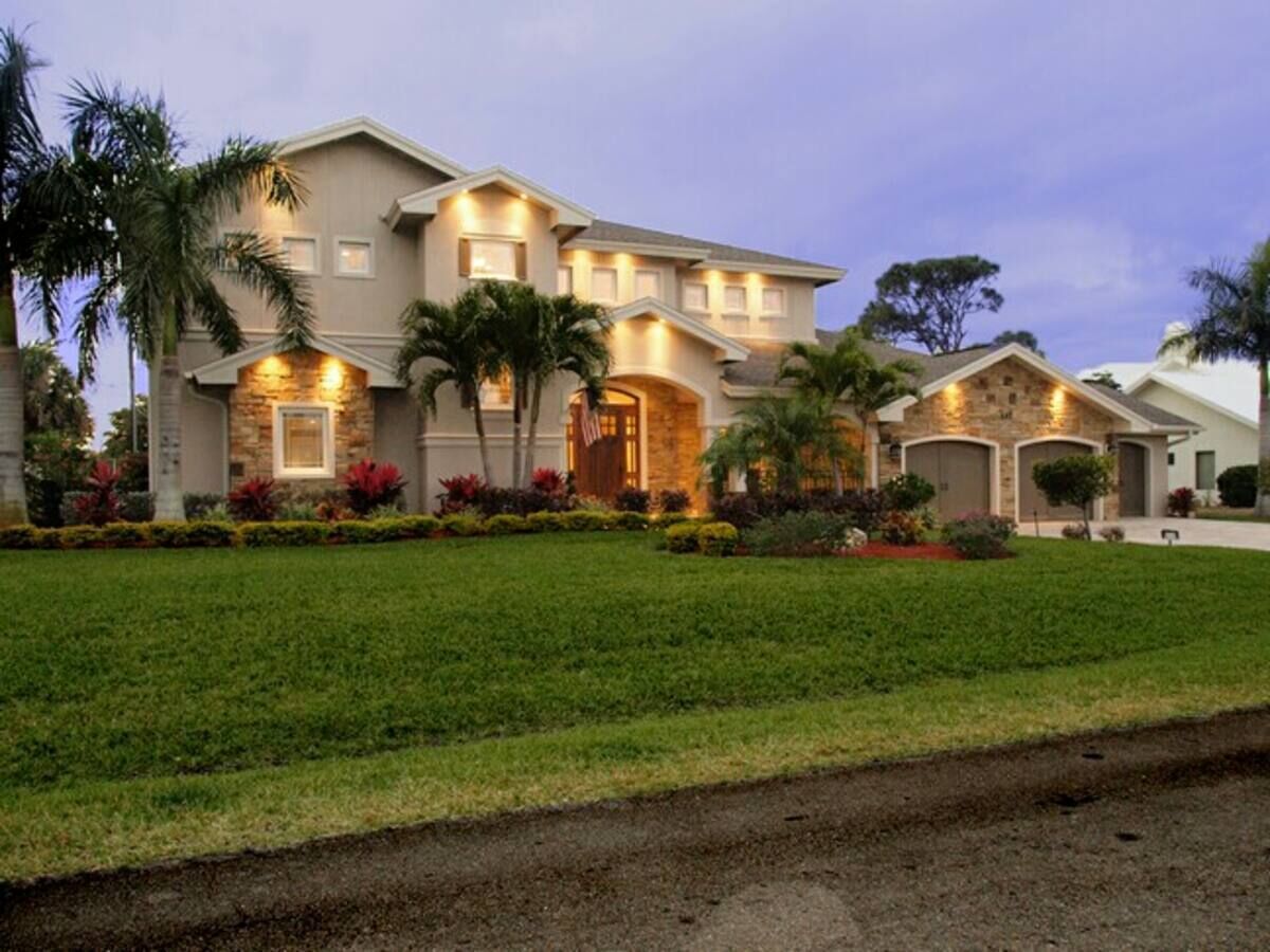 A large, two-story house with a well-maintained lawn and a driveway.