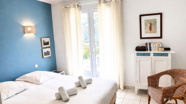 A bedroom with a bed, a chair, a cabinet, and a window with curtains. - Lenerie - 800m plage - Wifi - Parking (Préfailles)