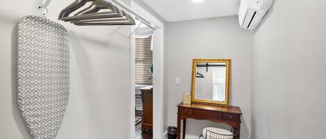 A bathroom with a wooden vanity, a mirror with a gold frame, and a towel rack.