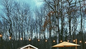Ein Whirlpool, umgeben von einer Holzterrasse, einem Grill und einer kleinen Holzhütte.