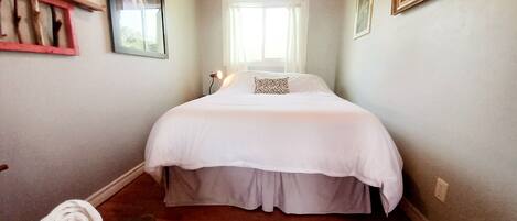 Une chambre à coucher avec un lit, une fenêtre et un plafond en bois.