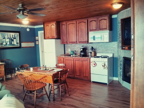 A kitchen with wooden cabinets, a refrigerator, a stove, and a dining table with chairs. - ☆7 Bdrm. Waterfront HIDEOUT☆ 1000•Islands•GETAWAY☆ (Gananoque)
