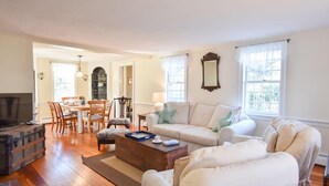 Un salon comprenant un canapé, une table basse et un coin repas avec des chaises et une table.
