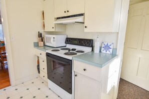 Eine kompakte Küche mit Herd, Mikrowelle und Backofen.