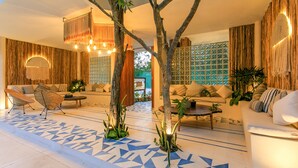A modern living room with a geometric patterned floor, a sofa set, and a coffee table. - Charming Nature-Inspired Condos with Sultry Surroundings by Stella Rentals (Tulum)