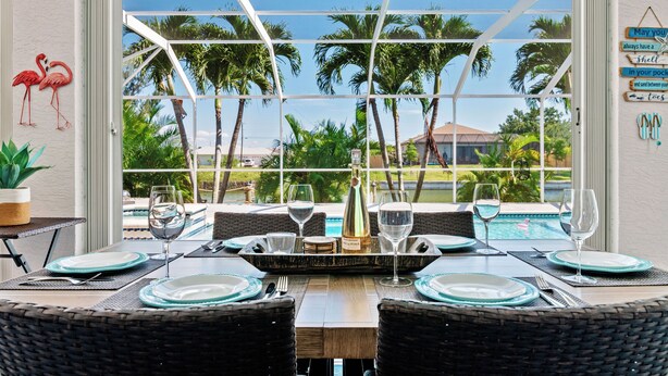 Comedor con vistas a palmeras y una piscina.