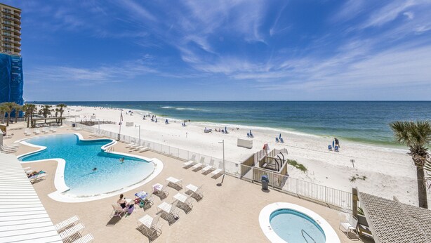 A resort pool area with a large pool, lounge chairs, and a beach view. - Ocean House 1304 | Heated, Zero Entry Pool | Oceanfront Balcony | My Beach Getaways (Gulf Shores)