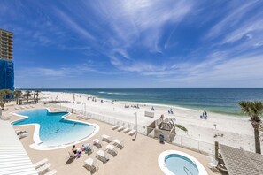A resort pool area with a large pool, lounge chairs, and a beach view. - Ocean House 1304 | Heated, Zero Entry Pool | Oceanfront Balcony | My Beach Getaways (Gulf Shores)