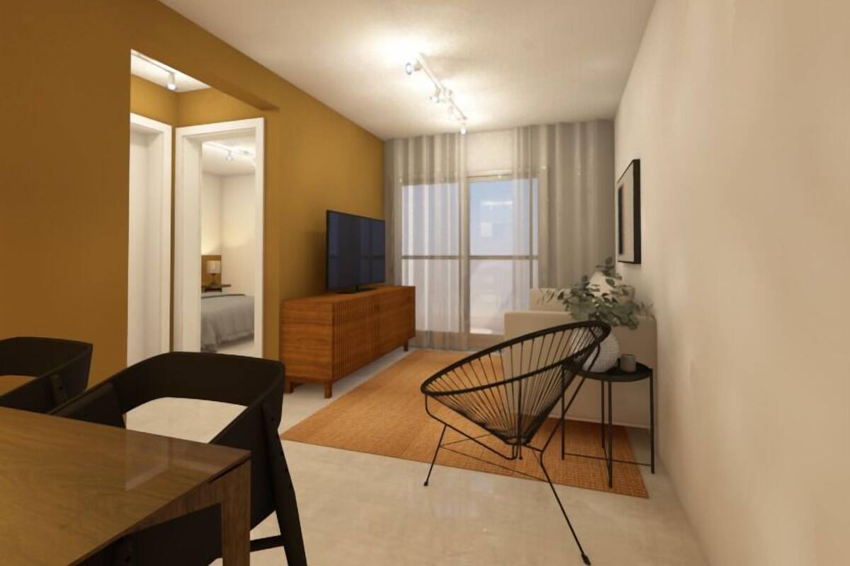 Una sala moderna con comedor, un televisor sobre un mueble de madera y un amplio ventanal con cortinas.