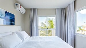Une chambre d’hôtel avec un lit, une fenêtre avec des rideaux et un climatiseur fixé au mur.