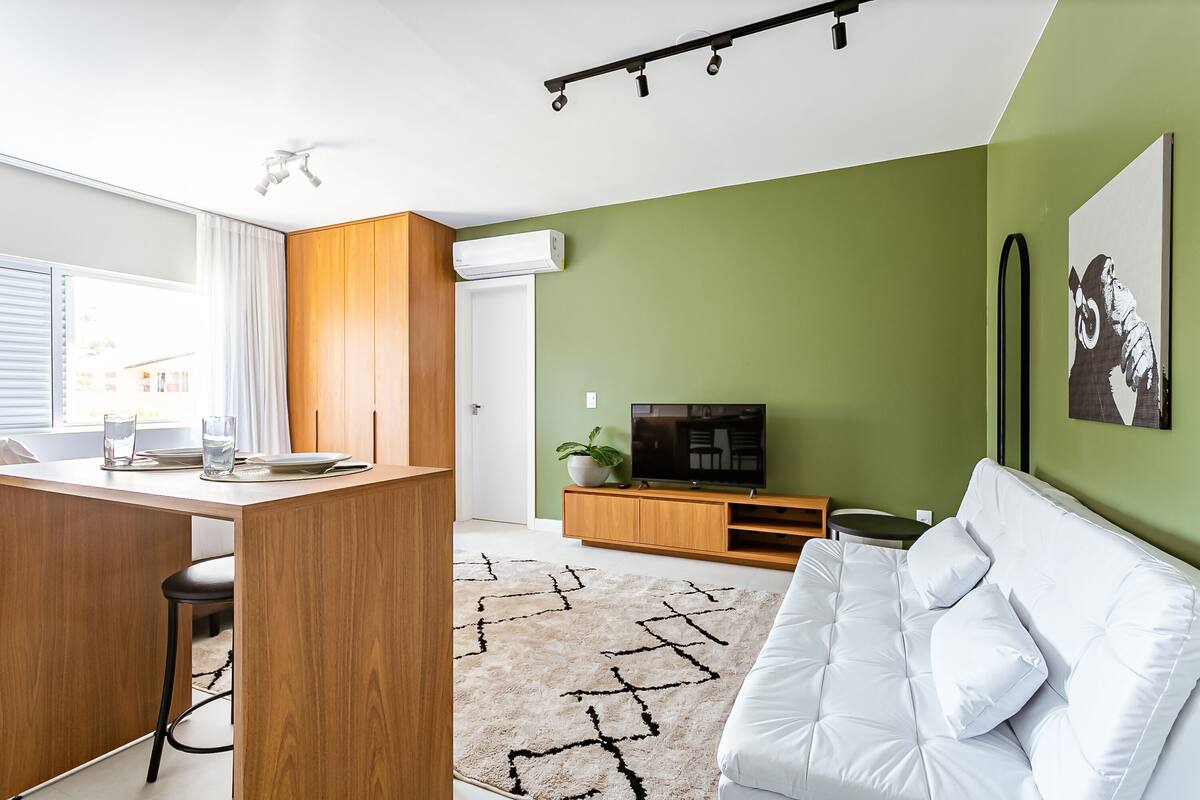 Una sala de estar moderna con un sofá, un televisor y un mueble de madera.