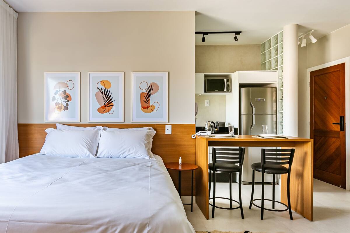 Habitación de hotel con cama, escritorio con dos sillas, microondas y refrigerador.