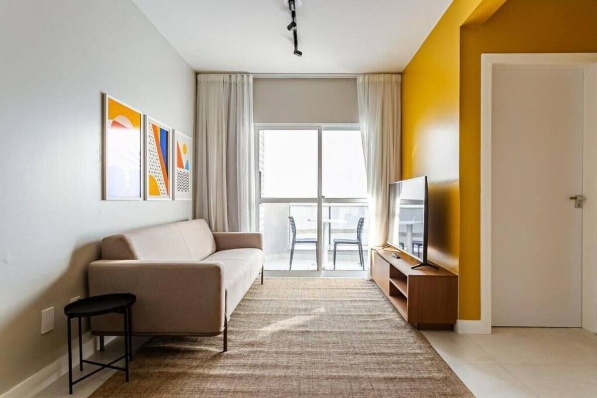 Una sala de estar moderna con un sofá, una mesita, un televisor y un balcón con vistas.