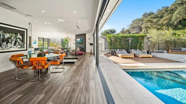 A modern interior with a dining area, a pool, and a view of the outdoors.
