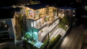 Una casa a più piani con un balcone, un'area salotto esterna e una scala.
