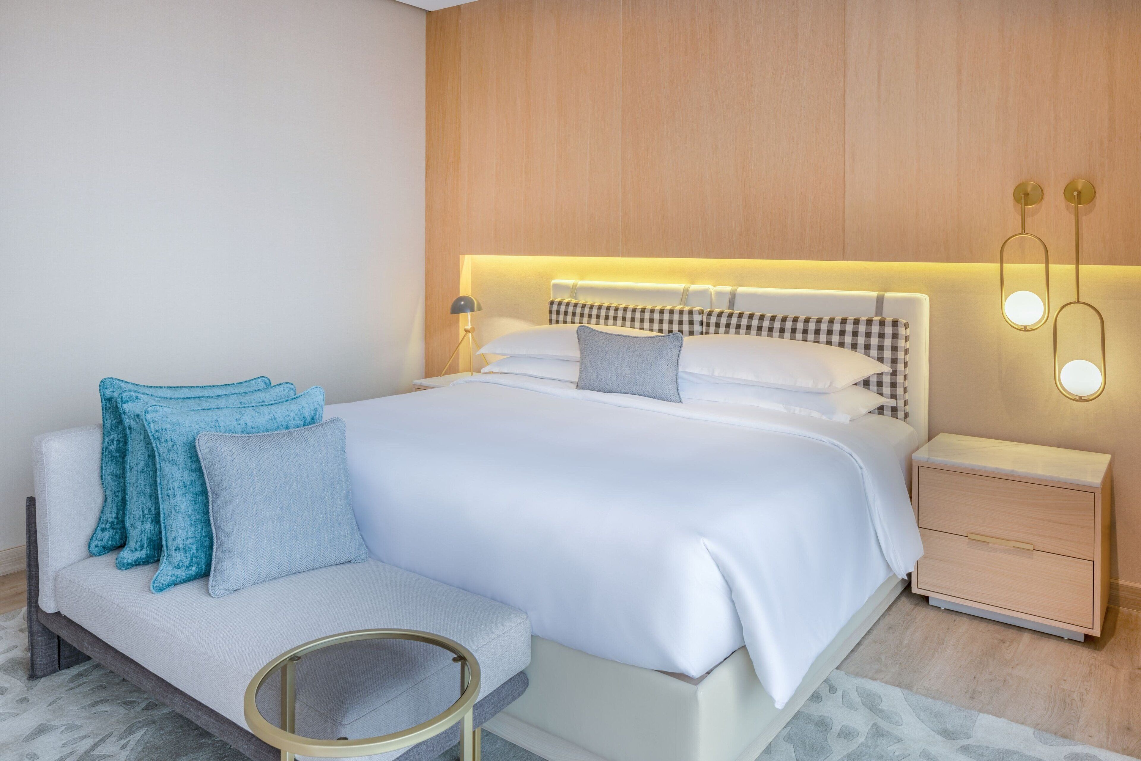 A modern bedroom with a bed, bedside tables, and a seating area.