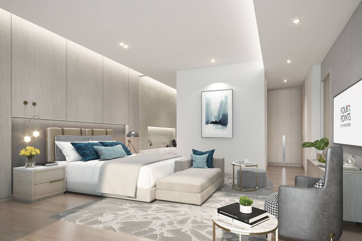 A modern bedroom with a large bed, bedside tables, a small sofa, and a desk with a chair.