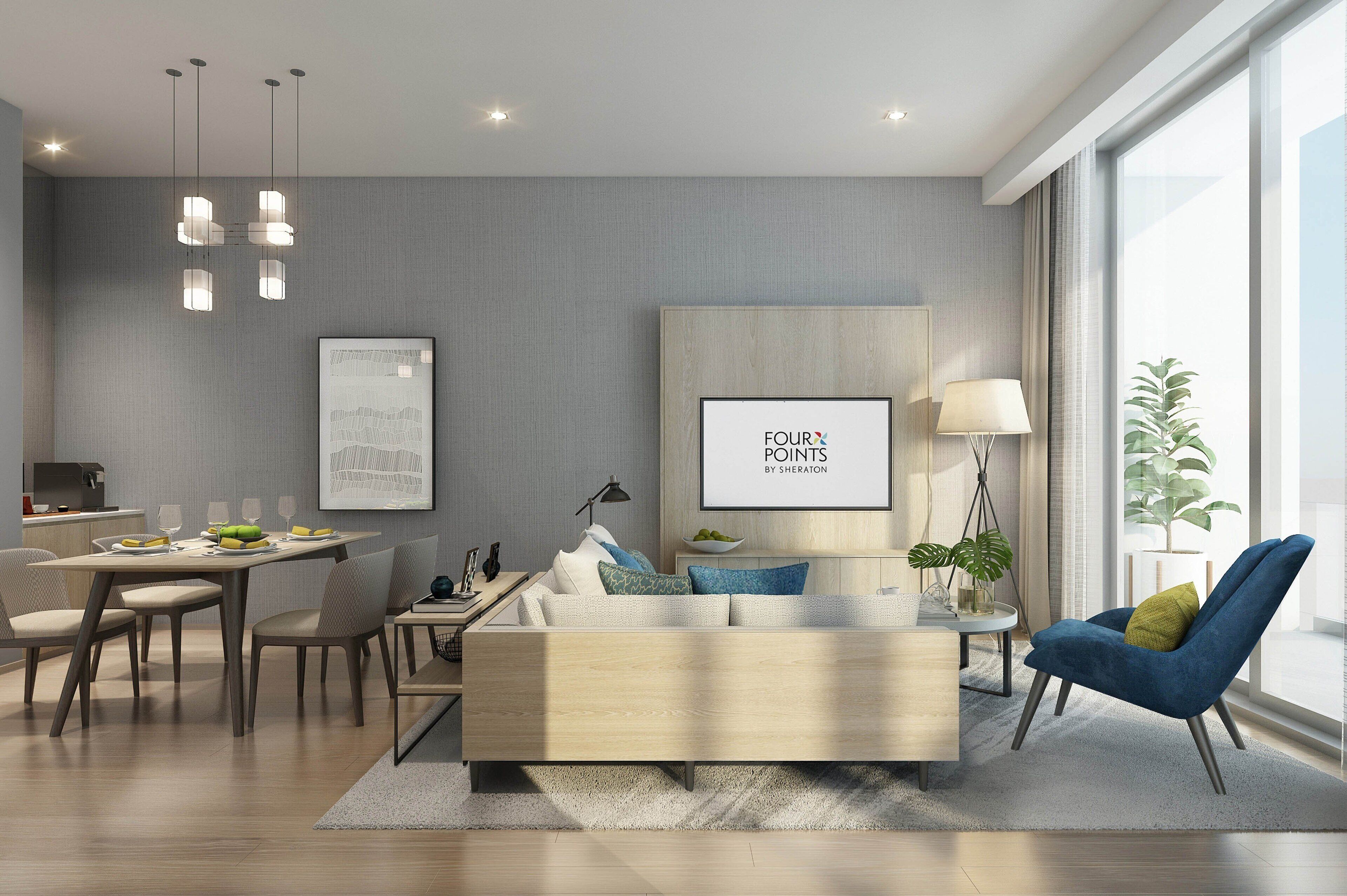 A modern living room with a sofa, dining table, and chairs, a large window, and artwork on the wall.