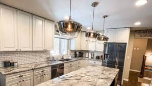 A modern kitchen with a large marble island, stainless steel appliances, and pendant lighting. - THE FAMILY FOREST · ★3 Acres Of Forest★Lighted Yard★Chef Kitchen★ (Colorado Springs)