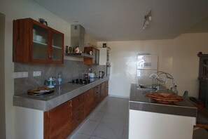 A kitchen with wooden cabinets, a stainless steel countertop, a built-in oven, and a sink.