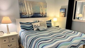 Una camera da letto con un letto, un comodino, una lampada, un quadro e uno specchio.