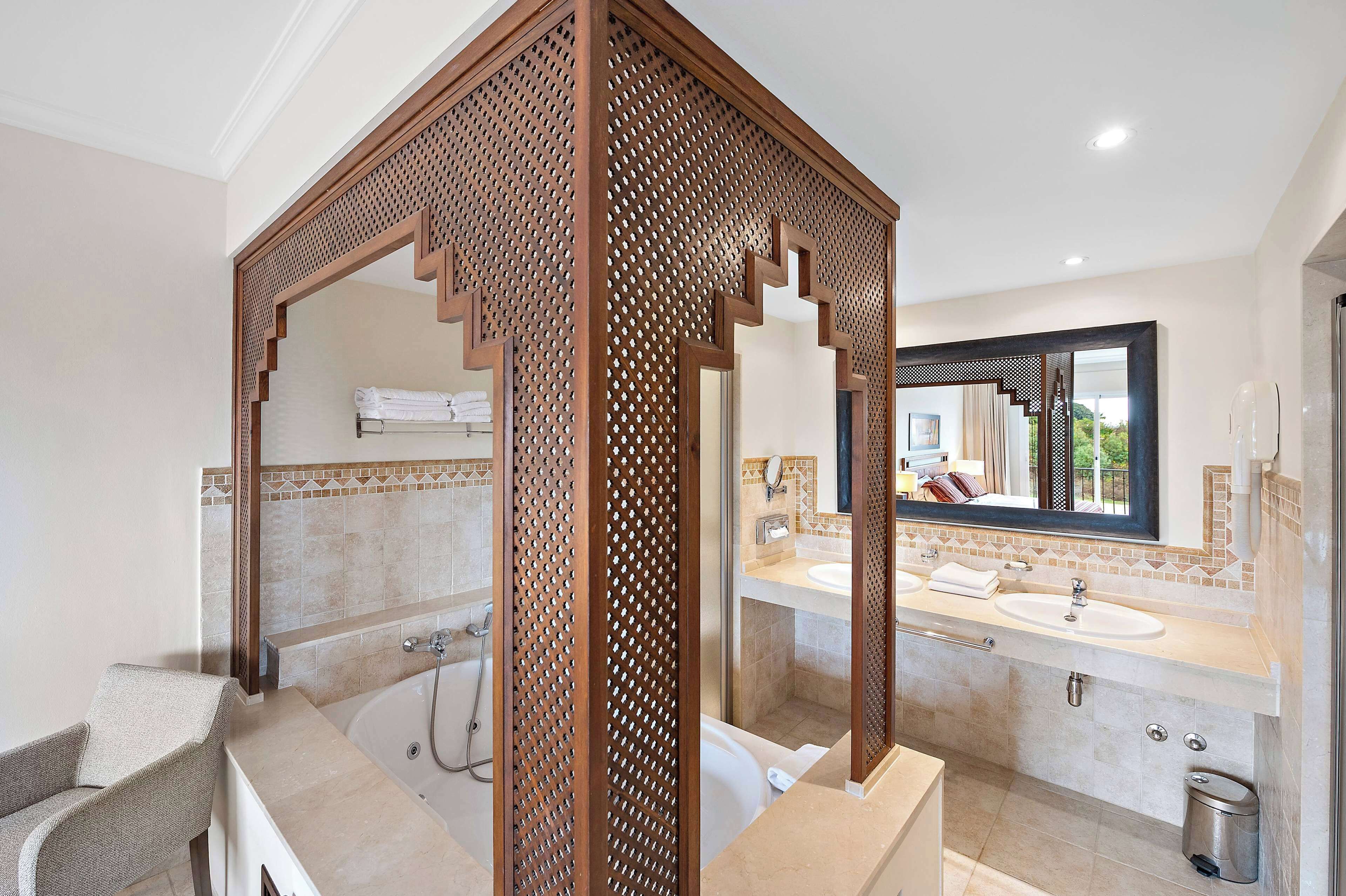 Une salle de bain moderne avec une baignoire sur pieds, deux vasques et un grand miroir.
