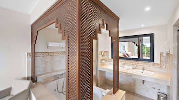 Une salle de bain moderne avec une baignoire sur pieds, deux vasques et un grand miroir.