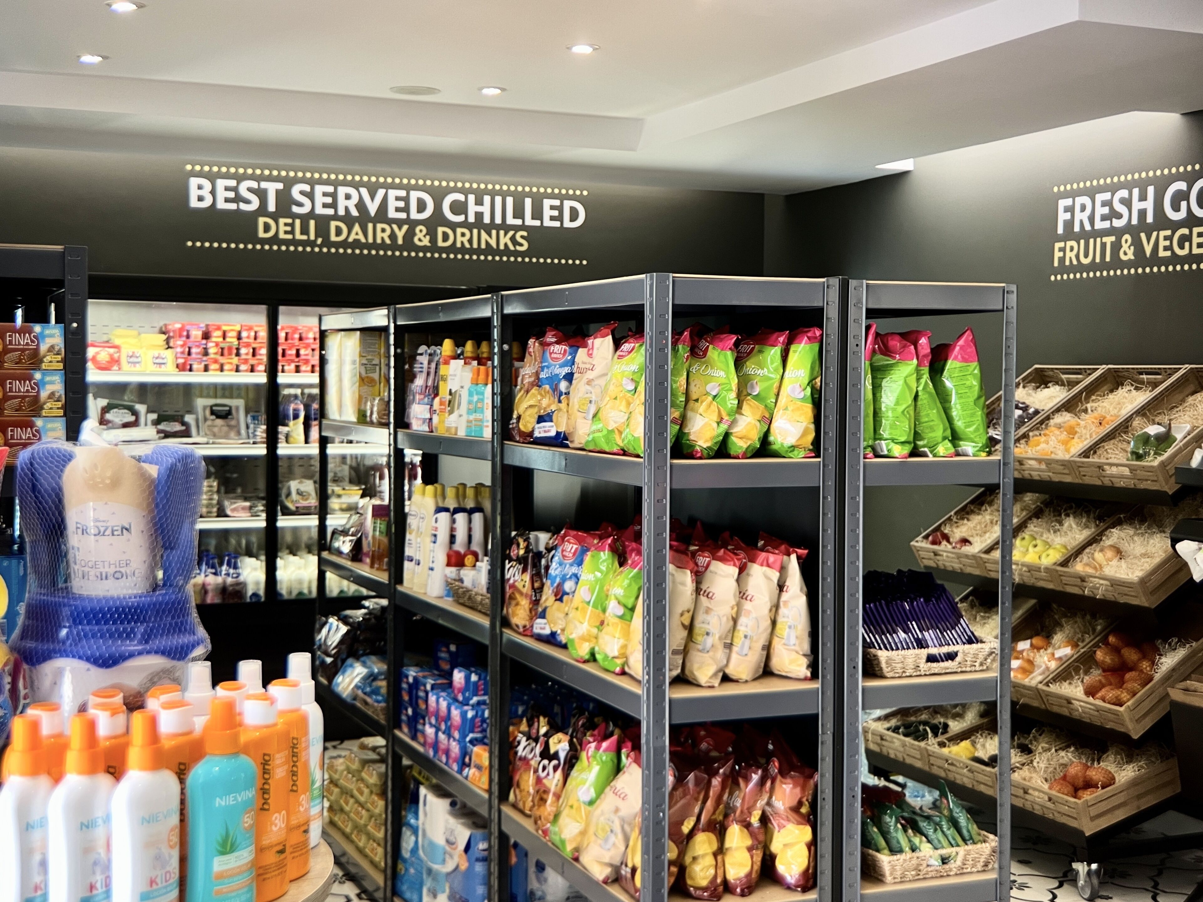 A refrigerated section with chilled dairy, deli, and drinks, and a fresh produce area with fruits and vegetables.