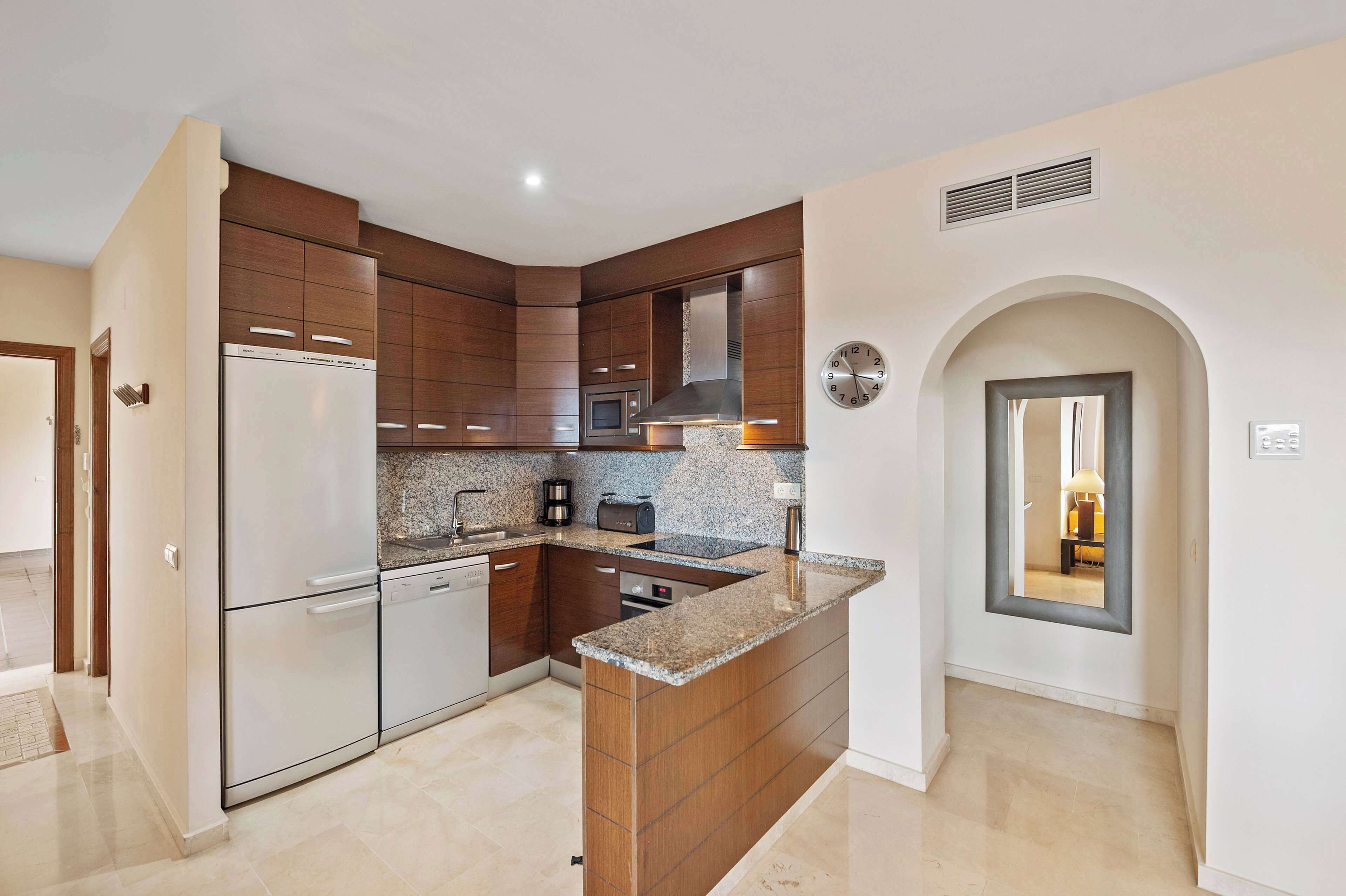 A modern kitchen with a built-in island, stainless steel appliances, and a microwave.