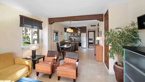 Una sala de estar moderna con un sofá, sillas, una mesa de comedor y una cocina al fondo.