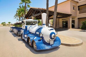 A blue and white train parked in front of a building with a sign that reads "Wyndham Grah Residences". - Wyndham Grand Costa del Sol (Mijas)