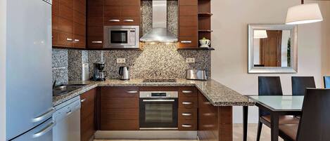 A modern kitchen with granite countertops, stainless steel appliances, and wooden cabinetry.