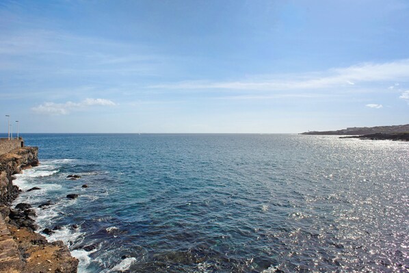 A coastal view with a rocky shoreline, a clear sky, and calm sea. - Holiday Apartment 'La Garita Beach' with Wi-Fi (La garita)