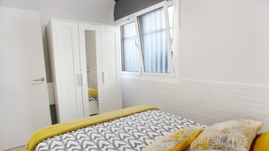 Un dormitorio con una cama, un armario y una ventana.