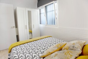 Ein Schlafzimmer mit Bett, Kleiderschrank und Fenster.