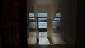Un pasillo que conduce a un balcón con vista al mar.