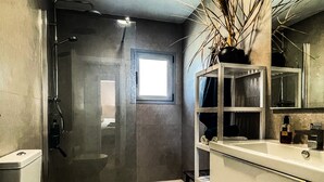 Une salle de bain moderne équipée de toilettes, d’une douche et d’un lavabo.