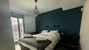Une chambre à coucher avec un lit, des lampes de chevet, une chaise et une fenêtre.