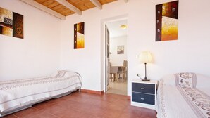 A room with two beds, a desk with drawers, a lamp, and artwork on the walls. - Apartment 'Beautiful 3-Bed' with Pool, Garden and Wi-Fi (Caleta De Fuste)